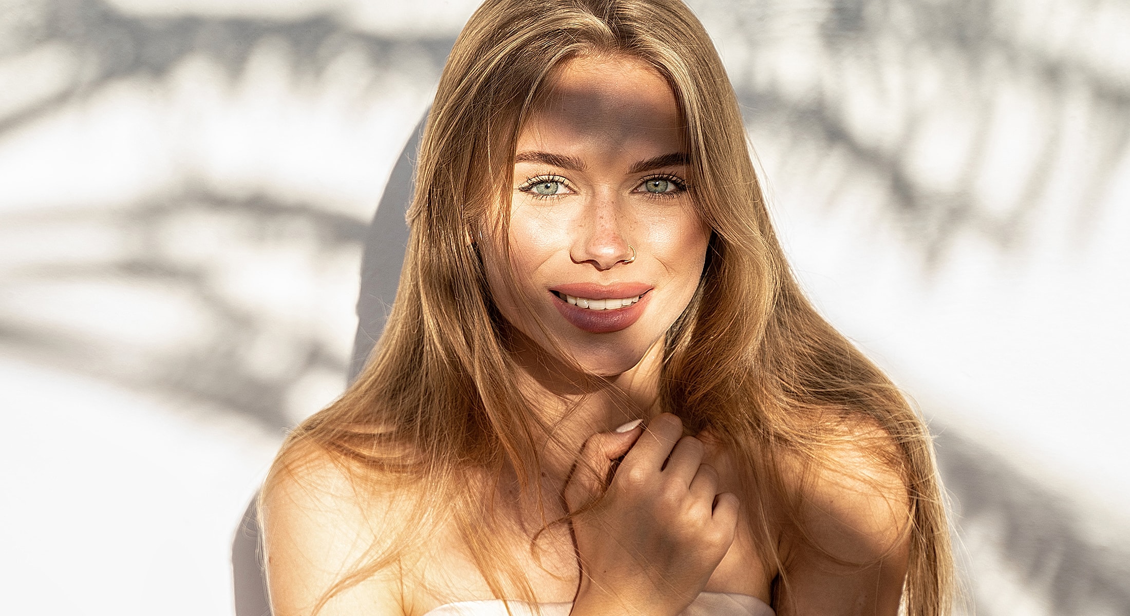 Woman smiling with sunlight and shadow effects.