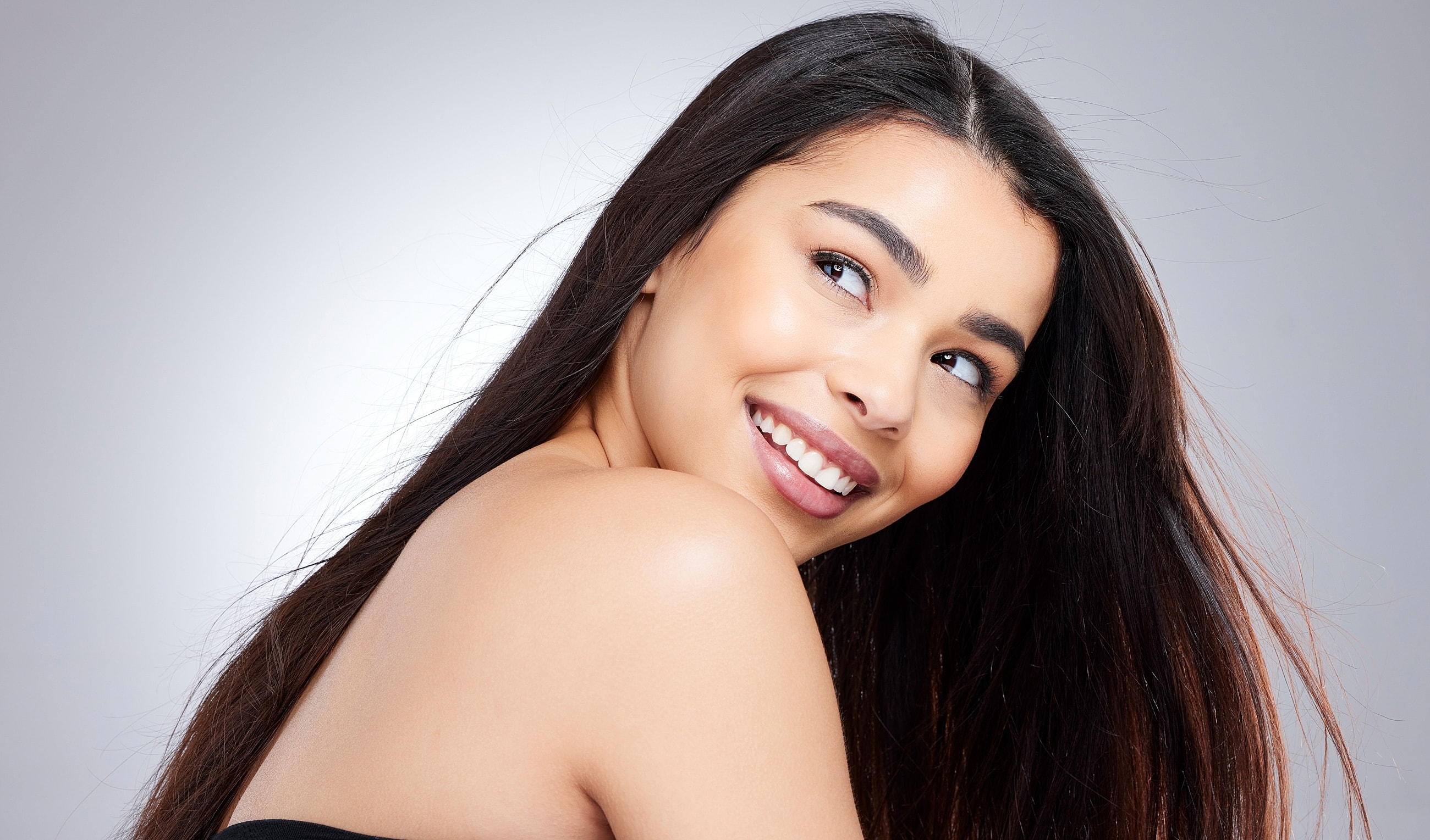 Newport Beach Med Spa model with long dark hair and glowing skin