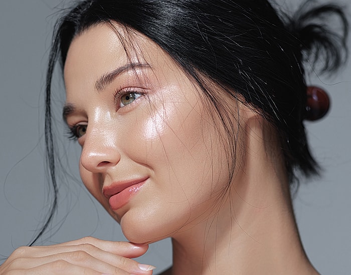 Woman with glowing skin and soft makeup.