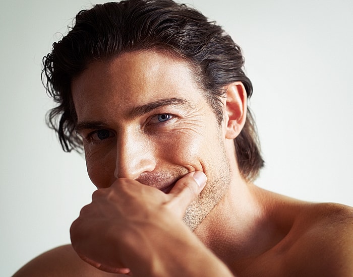 Smiling man with hand on chin background.