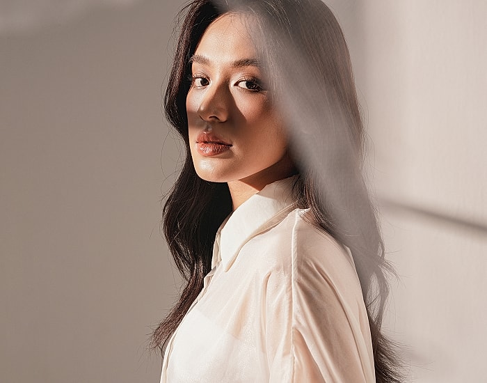 Woman with long hair in soft lighting.
