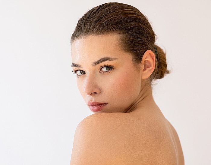 Woman with a serene expression and smooth skin.